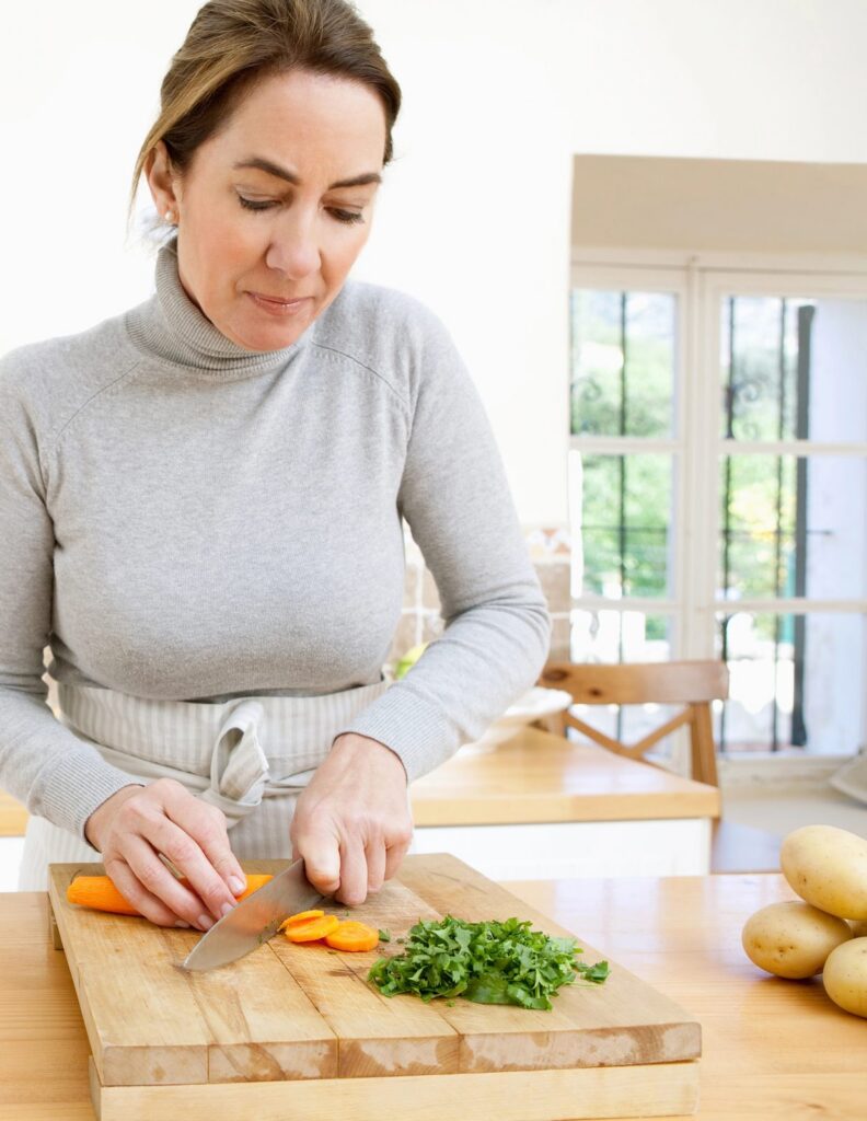 Una donna taglia le verdure in cucina