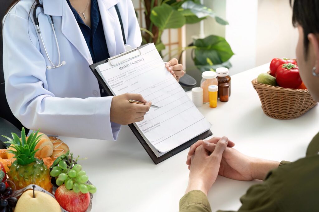 Il medico illustra la scheda al paziente, sul tavolo frutta e verdura